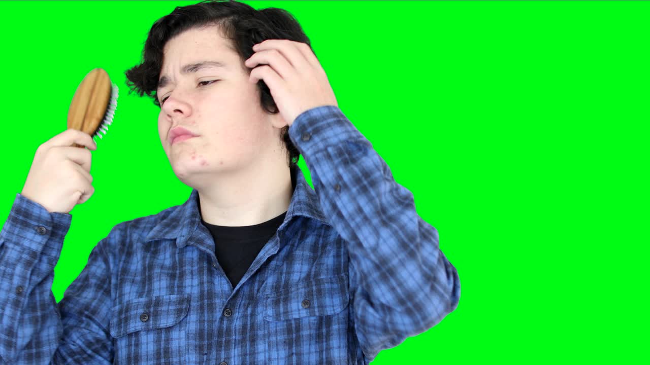 십대가 초록색 스크린 배경에서 머리를 고 있다