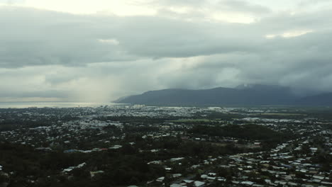 vista aérea de la ciudad australiana llamada cairns durante el día de nubes densas con montañas y océano en segundo plano