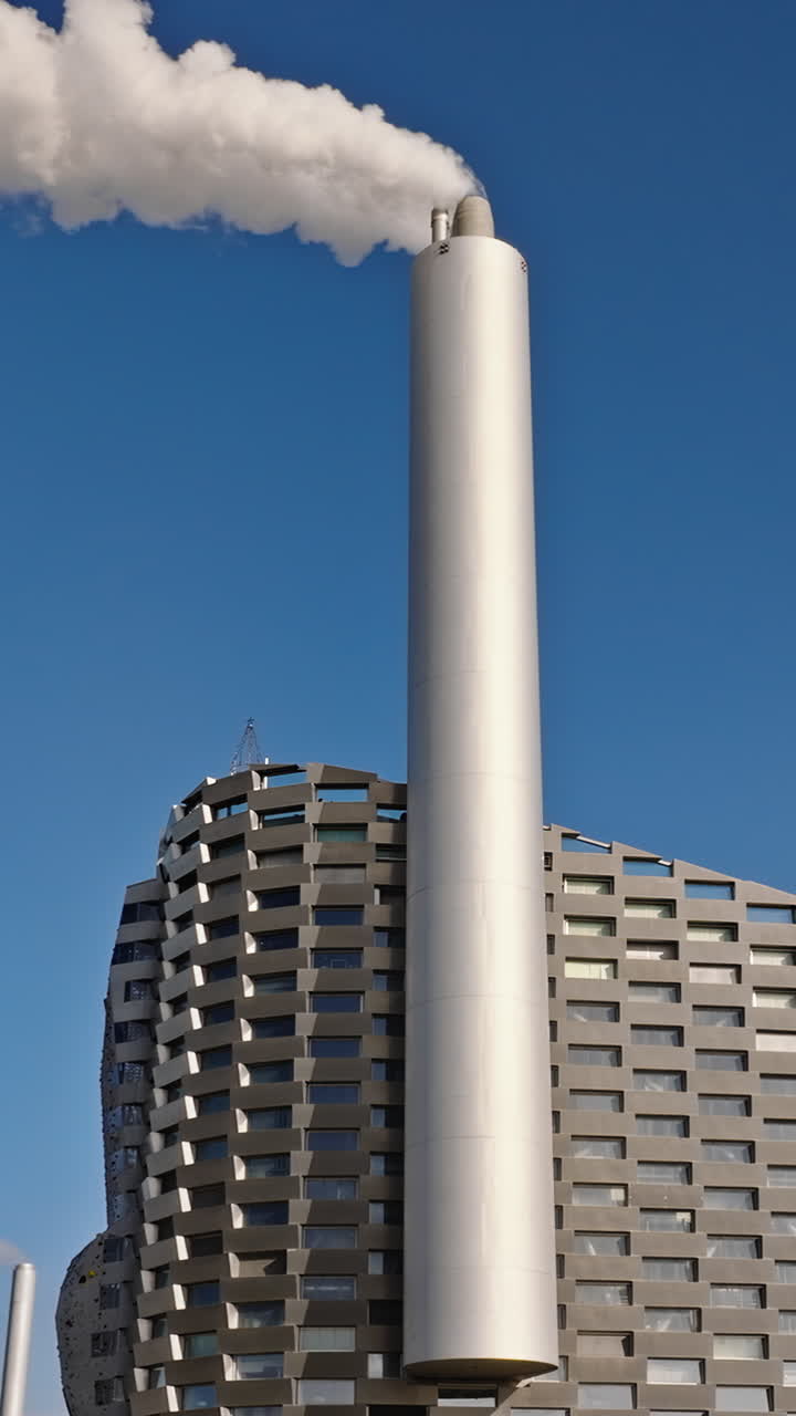 Aerial drone view of CopenHill artificial ski slope on the roof of an energy plant. Vertical
