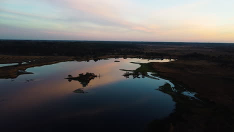Lake-reflecting-colorful-vivid-sky,-aerial-drone-view