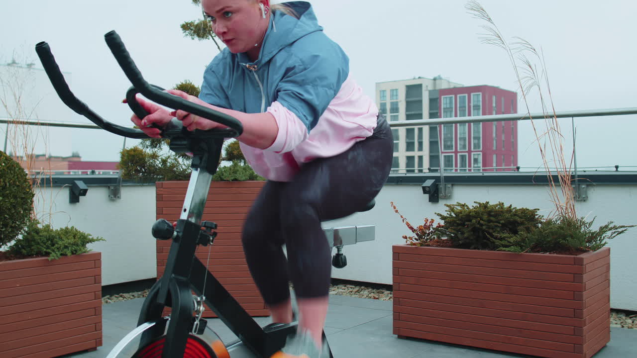 여성은 시 ⁇ 레이터, 사이클 트레이닝에서 유산소 지구력 훈련 운동 심장 루틴을 수행합니다.