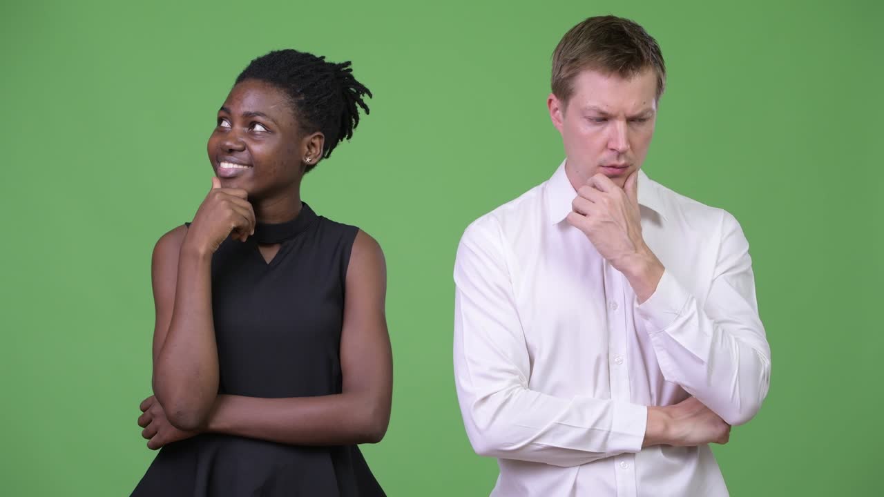 Two young multi-ethnic business couple thinking together