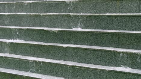 Observe the serene water flowing down urban steps highlighting nature's beauty in a clean cityscape.