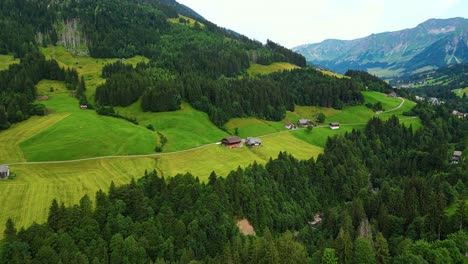 flying over sorenberg village in the swiss alps surrounded by mountains and pine trees, europe