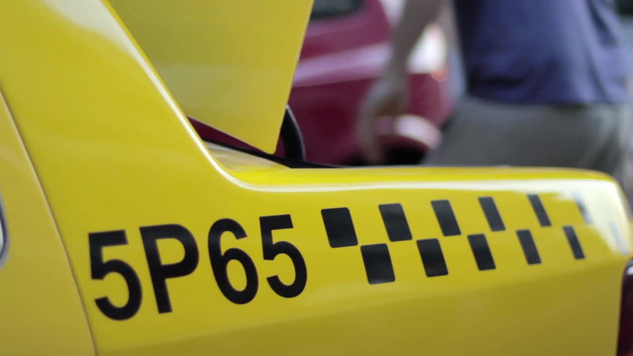 Apertura e chiusura del bagagliaio di un taxi giallo