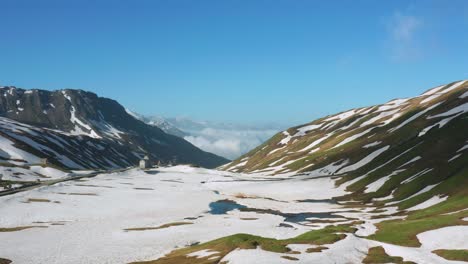 aerial view of snow covered landscape of the mountain under blue sky