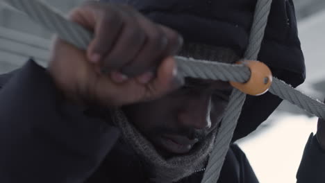 angry man pulling ropes outdoors