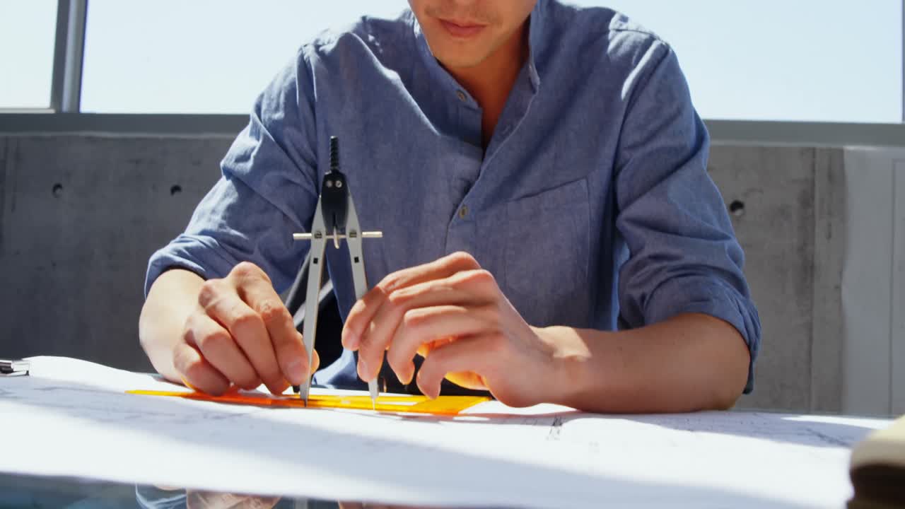 아시아 남성 건축가 가 현대적 인 사무실 4k 에서 책상 에서 청사진 을 작업 하는 전면 전망