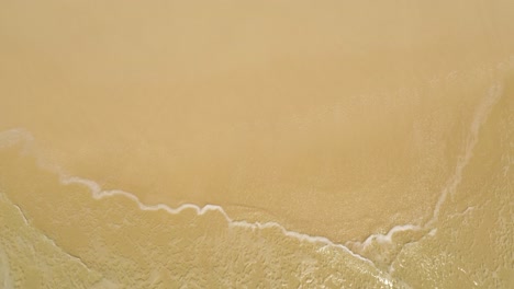 aerial view of sea waves on sandy beach