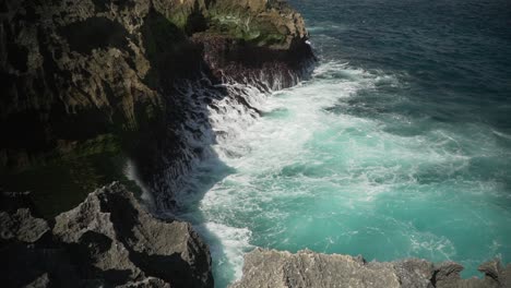 Luftaufnahme-Des-Kristallblauen-Wassers-Von-Angels-Billabong-In-Nusa-Penida,-Indonesien-Mit-Den-Wellen,-Die-Auf-Die-Klippen-Treffen