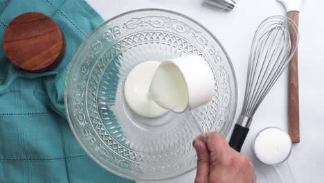 making a dessert called red raspberry tea cake made with fresh berries and vanilla buttercream frosting. great for tea parties. adding heavy cream or milk into the bowl to mix the cake batter