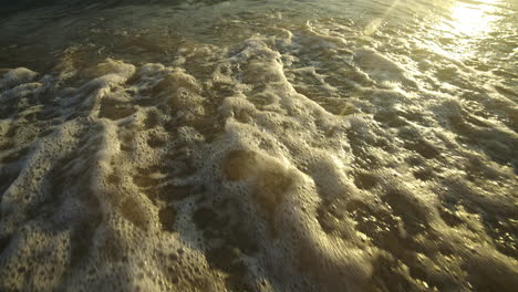 waves crashing on the shore at sunset