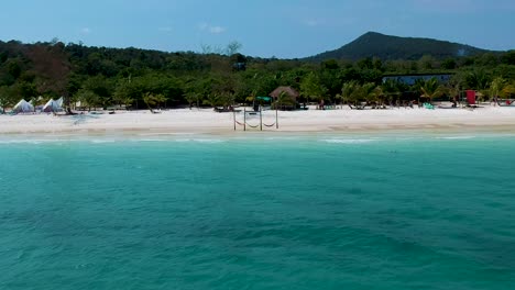 Luftschwenk-Am-Weißen-Sandstrand-Mit-Türkisblauem-Meer