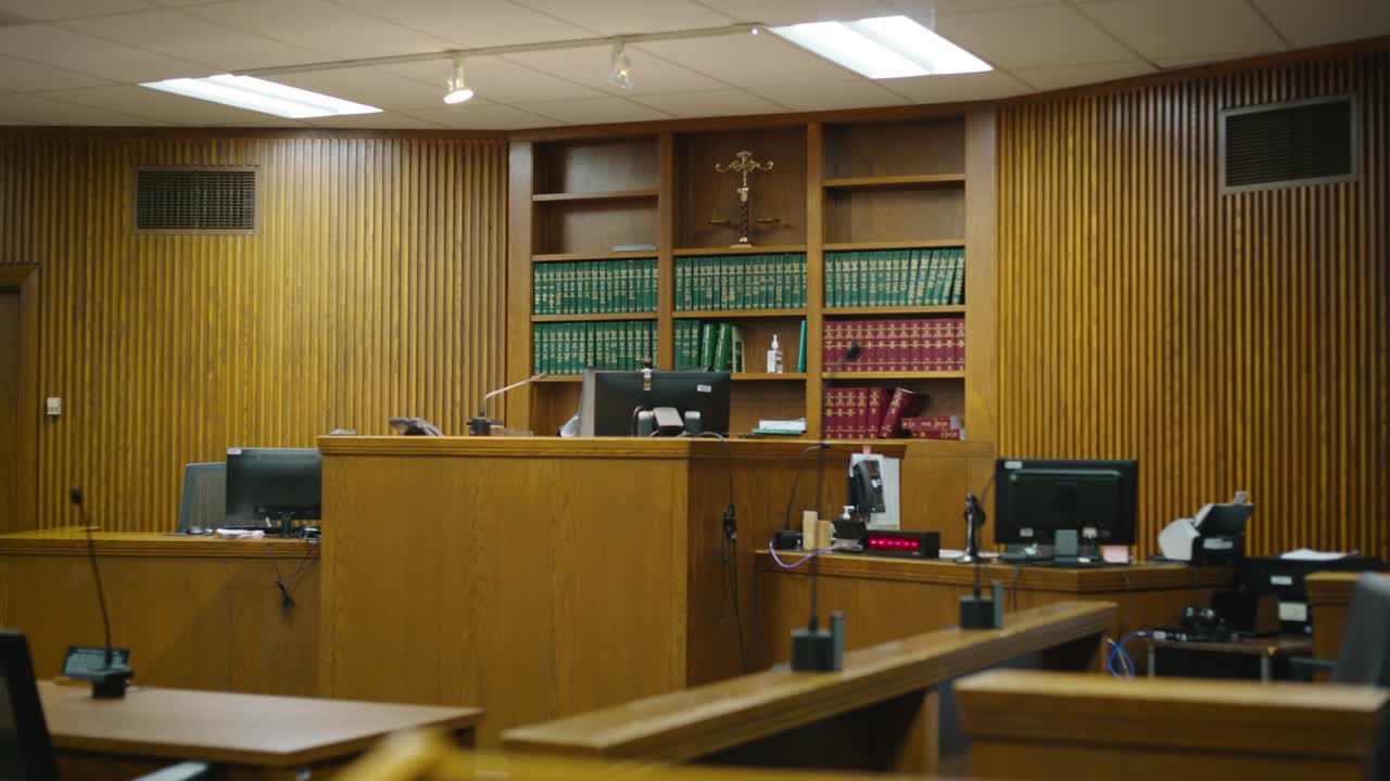 Capturing the essence of legal proceedings, this clip provides a glimpse into the formal setting, complete with the judge's bench, lawyers' tables, and the iconic witness stand