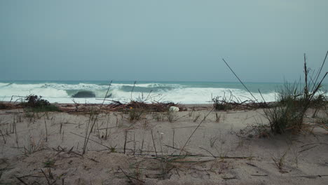 ocean waves crash on a sad and grey leaden day