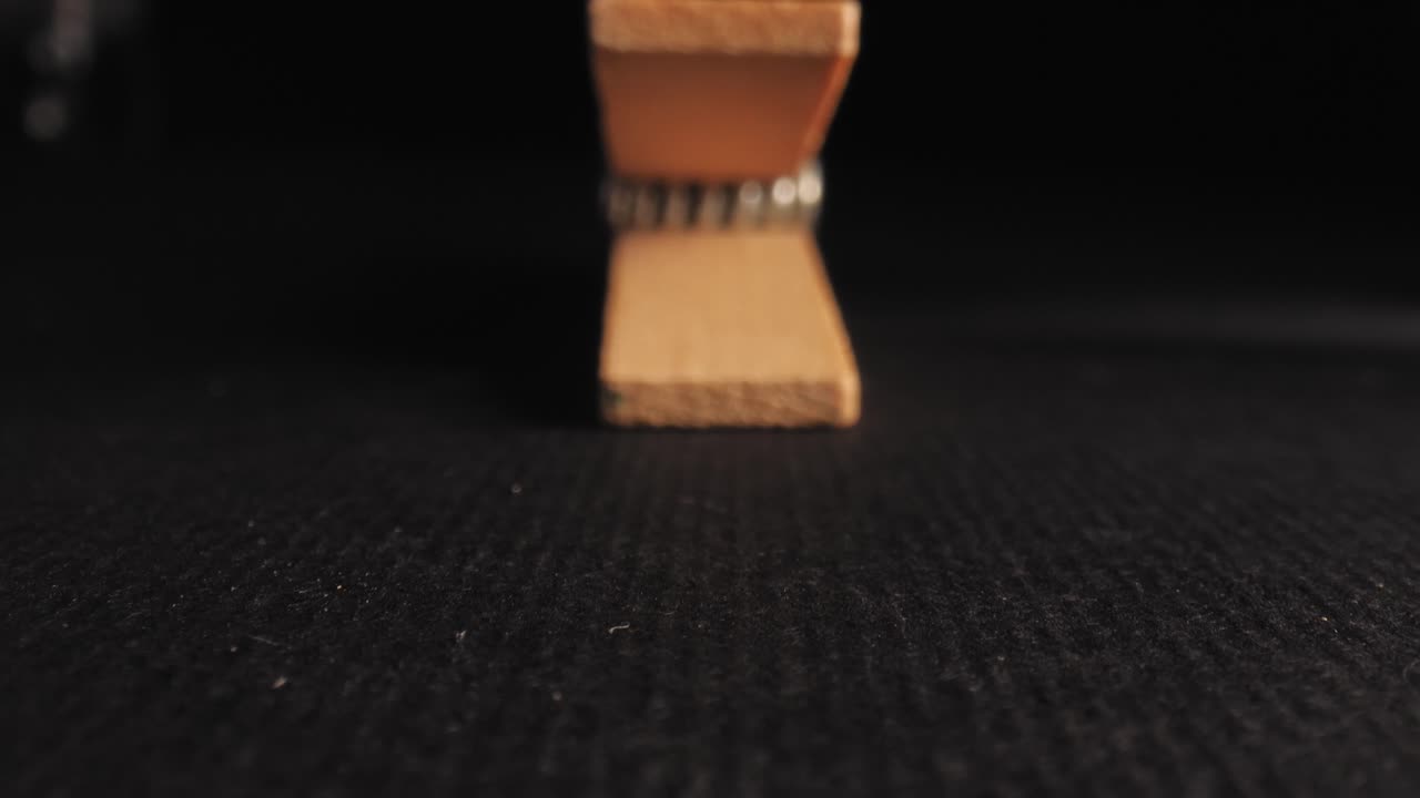 Approaching wooden clothes pen, macro shot with black background