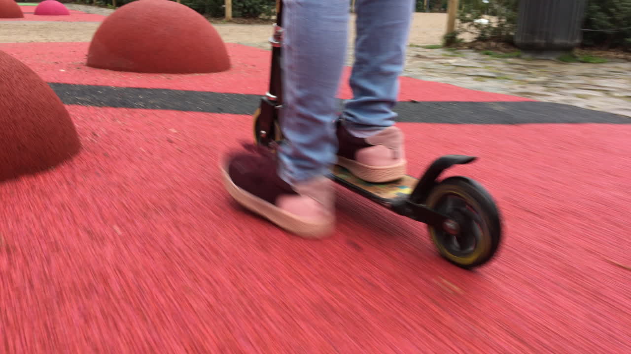primer plano de un niño montando scooter, tiro de seguimiento