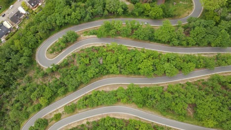 cars driving up a long curvy switchback road in west germany