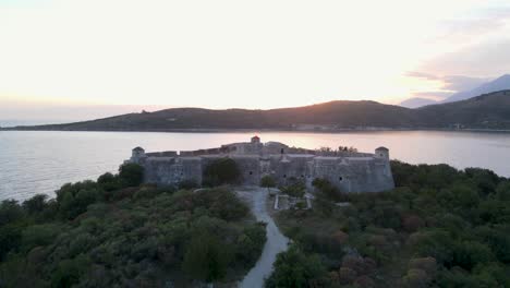 aerial-view-of-Ali-Pasha-Castle-and-Peninsula-Island-with-amazing-sunset-in-golden-sky,-Albania---Aerial