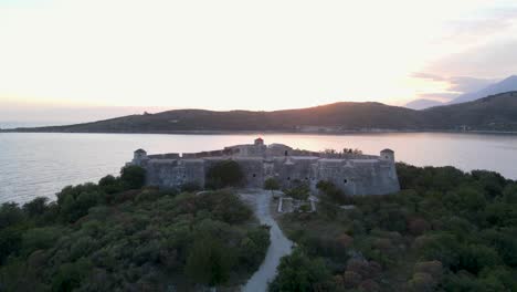vista aérea del castillo de ali pasha y la isla de la península con una increíble puesta de sol en el cielo dorado, albania - aérea