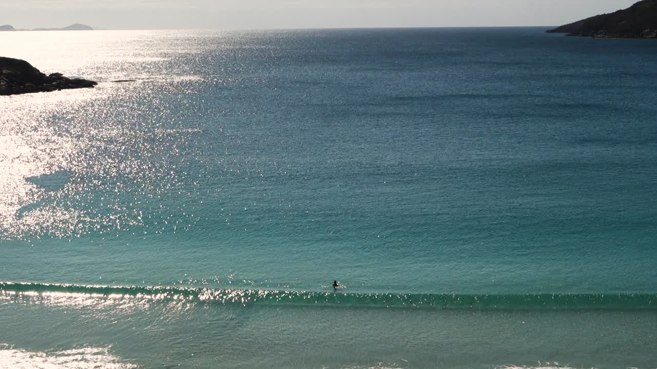 사람은 화창한 아침에 아름다운 해변에서 혼자 수영