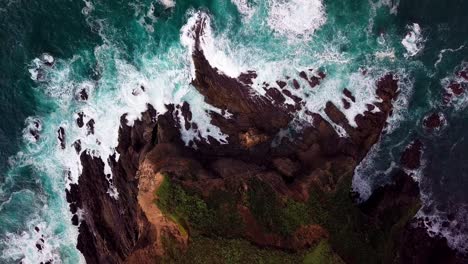 ocean waves break on rocky point in big sur cali, wide overhead drone shot