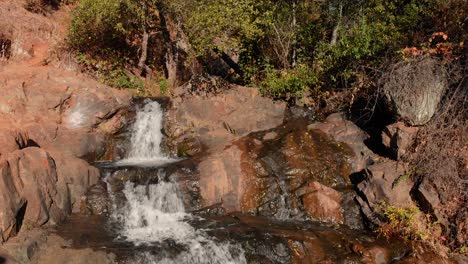 Close-up-aerial-view-of-Hidden-Falls-Regional-Park-waterfall-flowing-down-a-rocky-mountainside-in-Auburn,-California