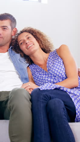 una pareja joven y linda viendo televisión.