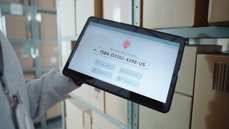 warehouse worker using tablet for package tracking