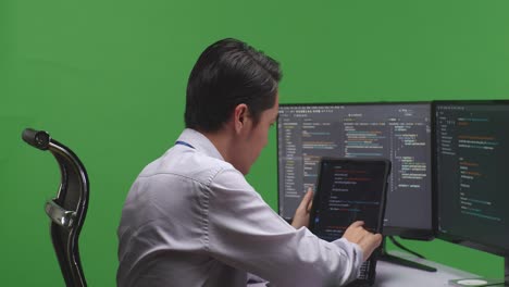 programmer working on code on tablet and monitor
