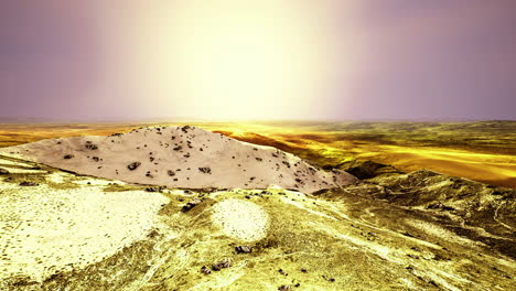 sunset over a golden desert landscape with rolling hills