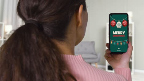 close up of woman at home looking at christmas online offers on mobile phone