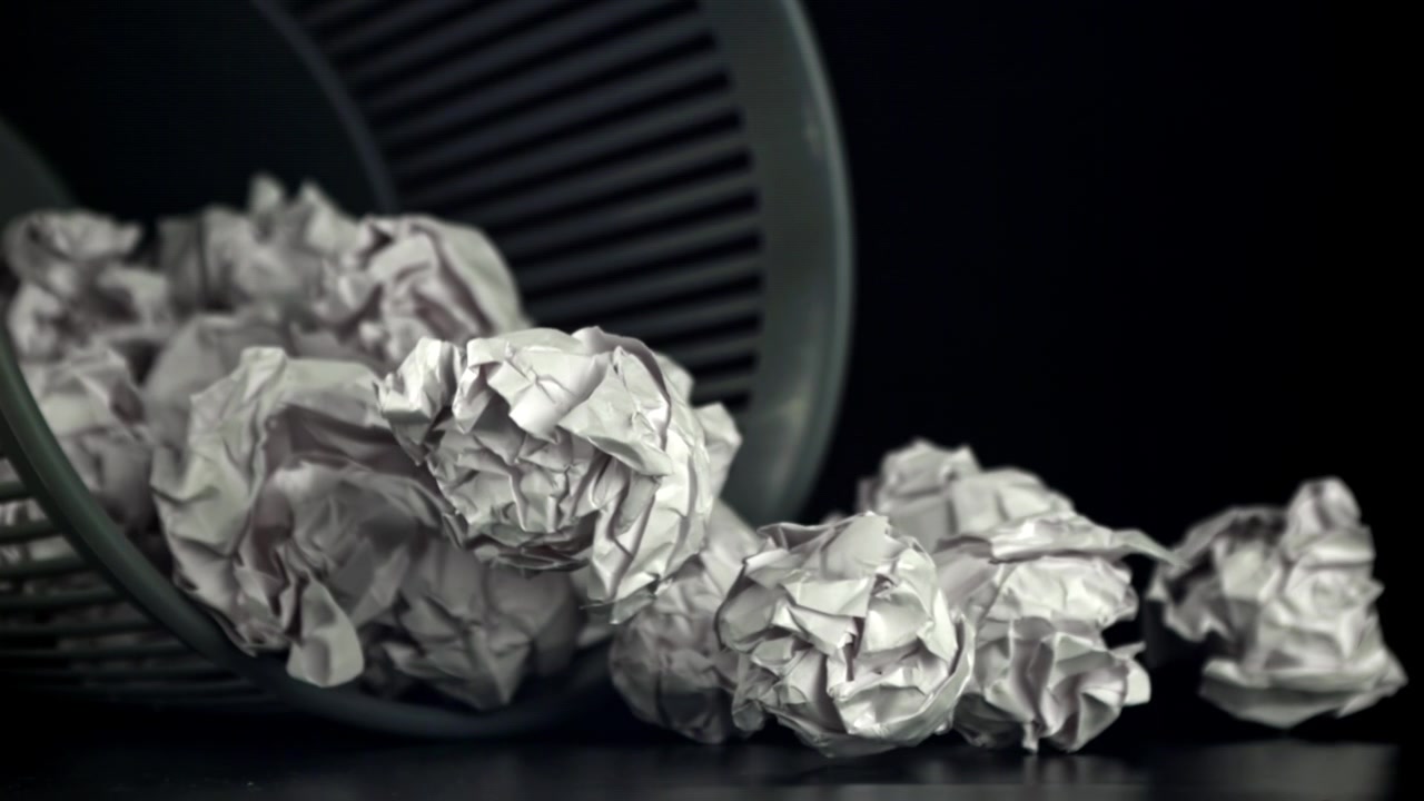 Crumpled Paper Spilling Out of a Wastebasket