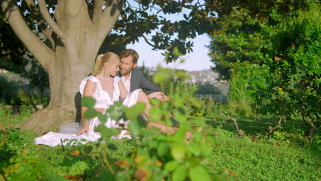 couple sitting underneath a tree in a garden