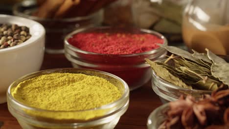 various spices in glass bowls close-up. middle eastern and arabian culture. seasoning and flavors. pepper, coriander, cinnamon, turmeric, paprika, bay leaf, star anise. dry herbs for cooking.