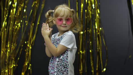 stylish child dancing, make faces, shaking shoulders in silly dance. little kid girl 4-5 years old