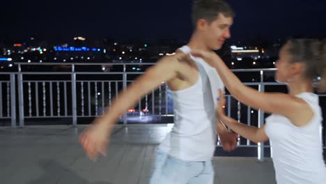 couple dancing on rooftop at night