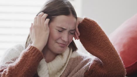 una triste adolescente caucasica seduta sul letto e che piange a casa