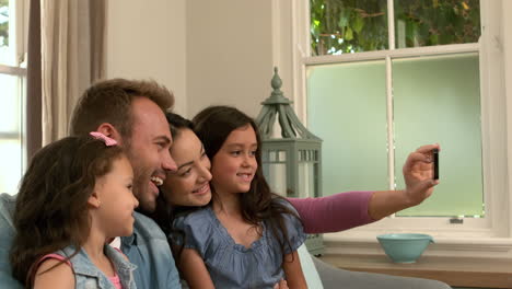 familia feliz tomando selfies en el sofá