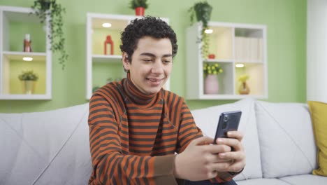 Niño-Feliz-Y-Lindo-Enviando-Mensajes-De-Texto-Por-Teléfono-En-Casa.