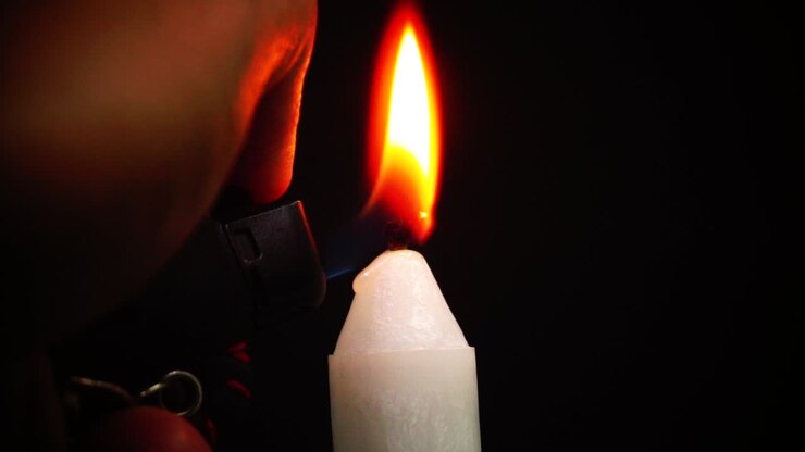 Una candela accesa da un accendino a gas.