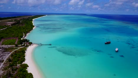 vue en grand angle sur le lagon des maldives, le vieux bateau en bois et le yacht de luxe ancré dans les eaux bleu aqua