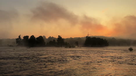 wide right panning shot of the james river (pony pasture) during a misty summer sunrise is richmond, virginia