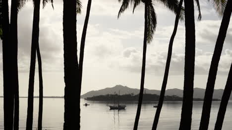 Beautiful-black-and-white-static-shot-of-sailboat-anchored-in-calm-waters-with-reflections