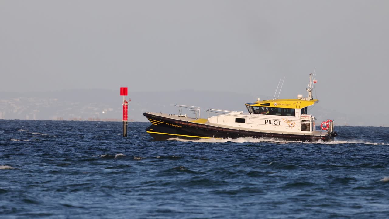 A pilot boat cruises through calm ocean waters near Great Ocean Road, under clear skies with steady camera focus