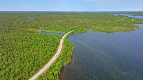 Drone-Rastreando-Una-Casa-Rodante-Conduciendo-En-El-Lago-Inarinjarvi-En-El-Lejano-Norte-De-Finlandia