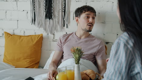 pareja disfrutando del desayuno en la cama