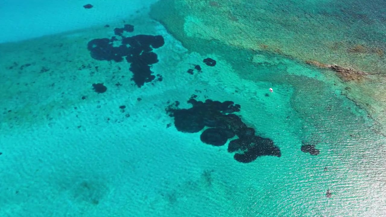Droneudsigt ovenfra af krystalklart, lavt turkist vand og mørke klipperev nær Gramvousa-øen, Gramvousa, Grækenland.