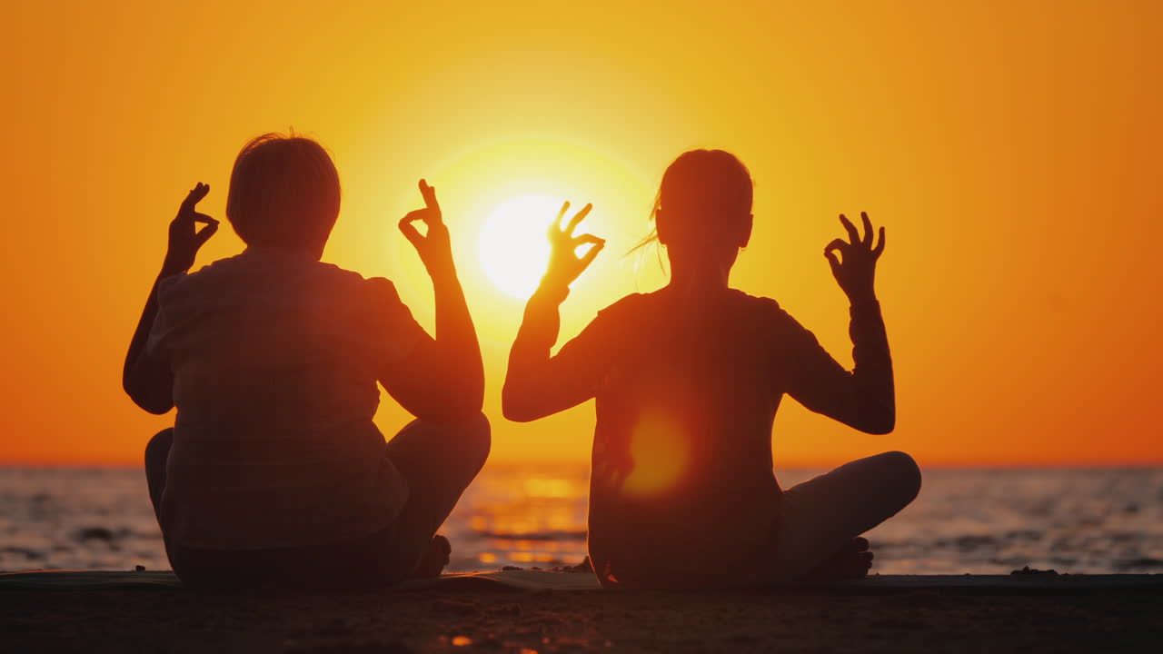 abuela y nieta meditan en la playa concepto de personas mayores activas y saludables