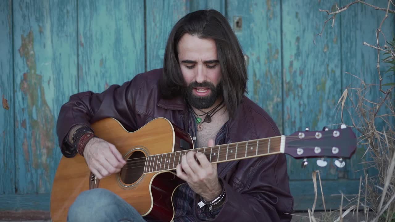 hombre tocando la guitarra acústica al aire libre
